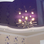 Цветной многоуровневый натяжной потолок с подсветкой и люстрой в гостиной