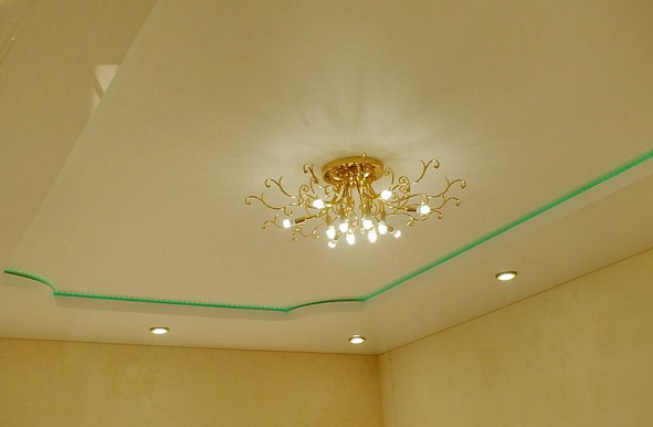 Белый двухуровневый натяжной потолок с подсветкой и люстрой в зале